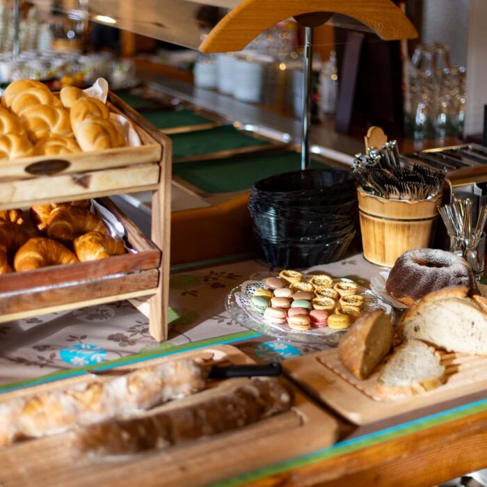 Brot und Gebäck auf einem Buffet mit verschiedenen Sorten von Brötchen, Croissants und Kuchen, ideal für ein Frühstücksbuffet oder eine Kaffeepause.