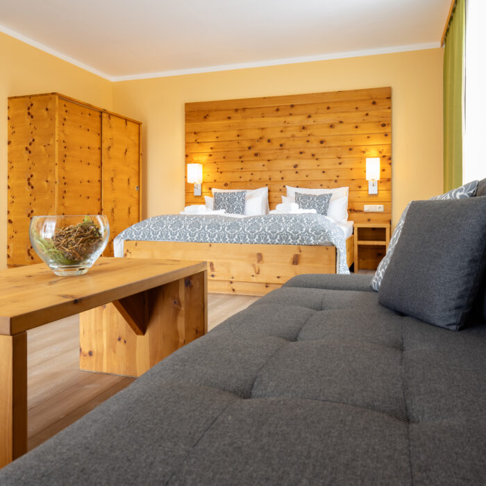Rustikales Schlafzimmer mit Doppelbett und Sofa