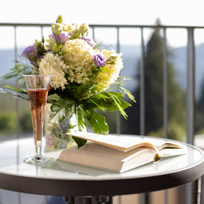 Blumen, Sekt und aufgeschlagenes Buch