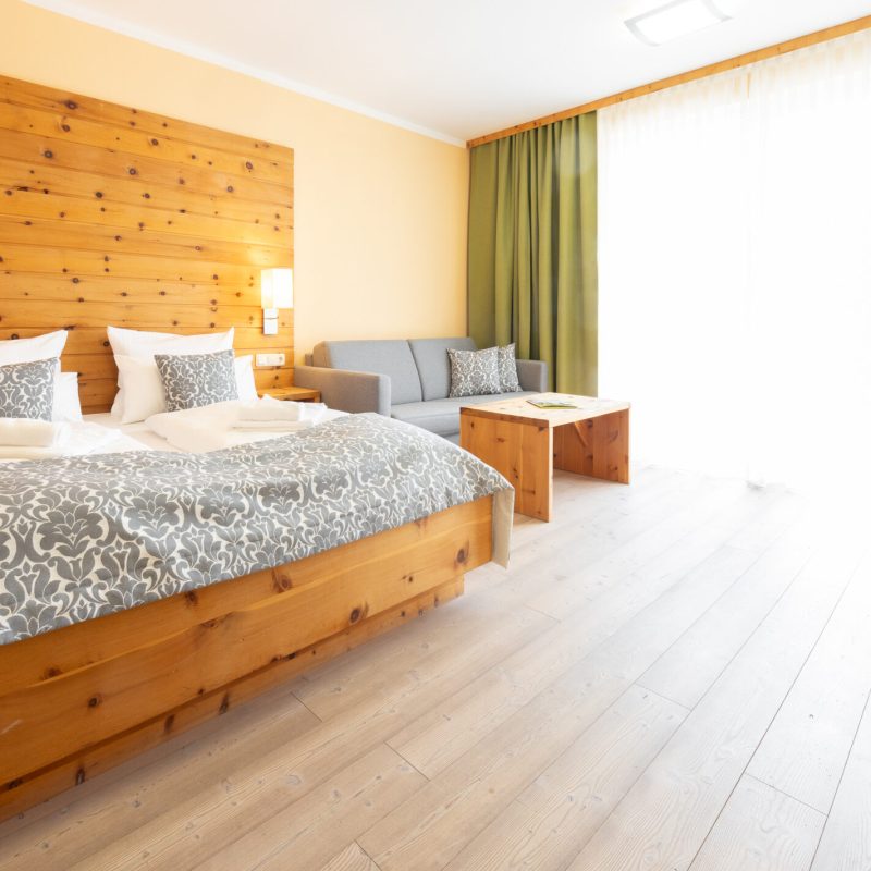 Helles Hotelzimmer mit Doppelbett und Sitzecke