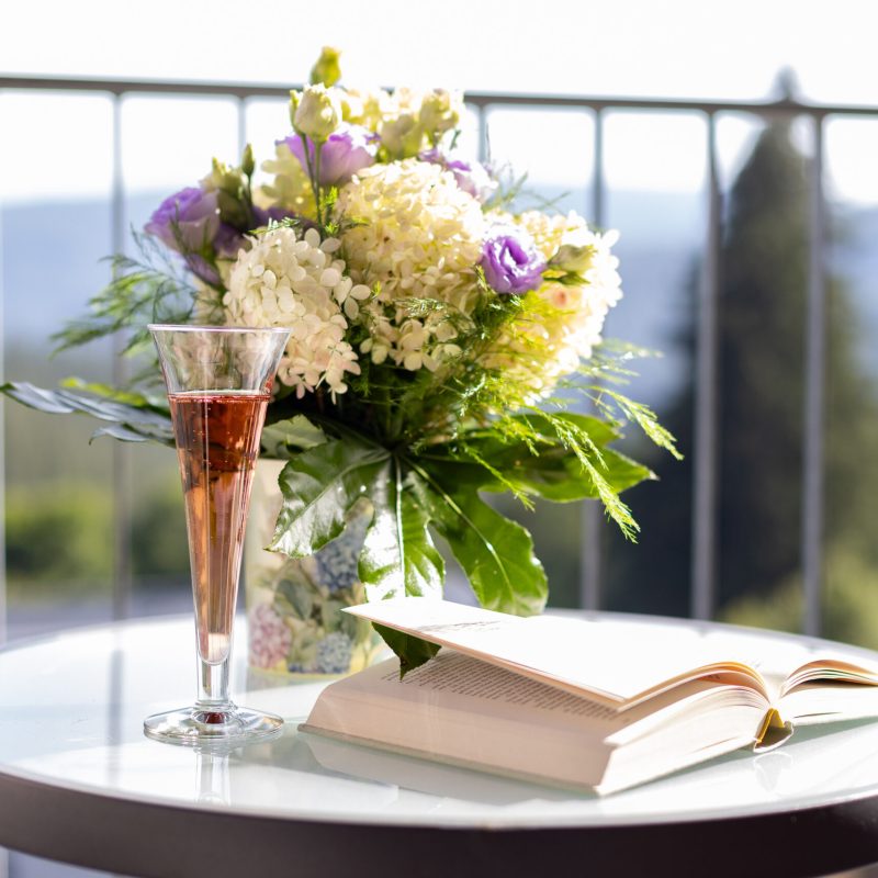Blumenstrauß, Sektglas und offenes Buch