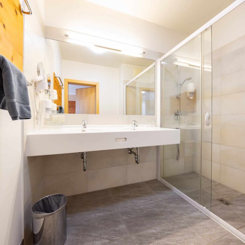 Badezimmer mit Doppelwaschbecken und Dusche
