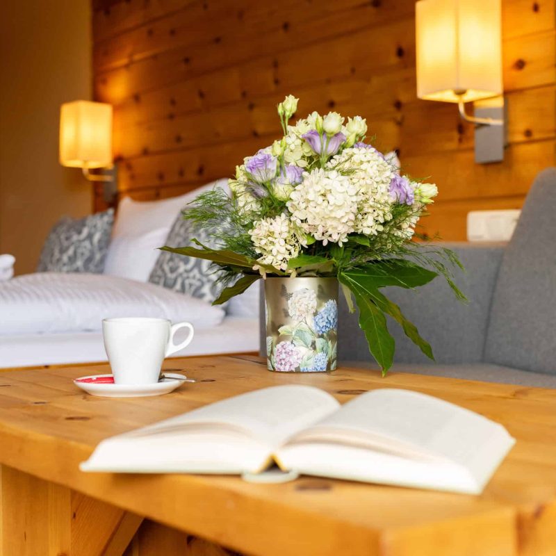 Blumenstrauß auf Holztisch in gemütlichem Zimmer